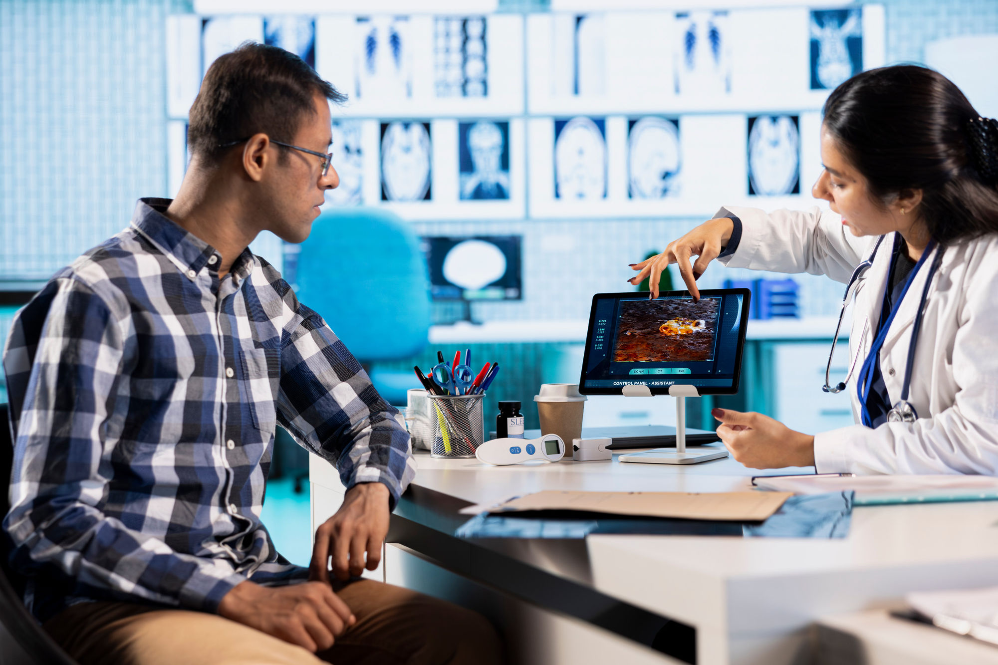 Scientific colleagues around a desk, one pointing at a portion of a screen